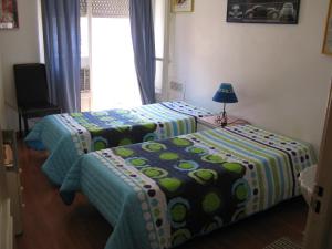 two beds in a room with a window at Residencial Nosso Lar in Lisbon