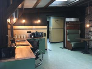 a kitchen with a wheelchair in the middle of a room at Boerderij Honswijck in Weesp
