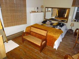 - une chambre avec un lit, une chaise et un miroir dans l'établissement LA BELLE D'ANTAN, à Saint-Bonnet-en-Bresse