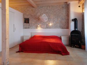 a bedroom with a red bed and a stone wall at Ferienhaus in Kavalos in Kávallos