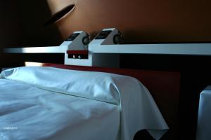 Diecizero Affittacamere في باروميني: سرير قريب وبطانية بيضاء