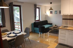 eine Küche und ein Wohnzimmer mit einem Tisch und Stühlen in der Unterkunft 4 Seasons Vlašić Lux Apartments in Vlasic