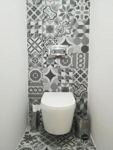 een badkamer met een toilet en een betegelde muur bij Irís Apartment in Pombal +30 foto's