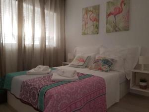 een slaapkamer met een bed met twee handdoeken erop bij Irís Apartment in Pombal