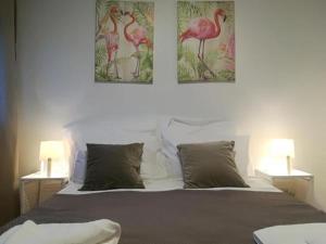 een slaapkamer met een bed met twee foto's aan de muur bij Irís Apartment in Pombal