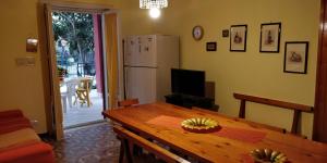 eine Küche mit einem Holztisch und einem Kühlschrank in der Unterkunft Villa Lina in Castel Volturno
