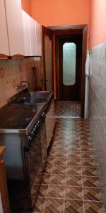 eine Küche mit Herd, Spüle und Tür in der Unterkunft Villa Lina in Castel Volturno