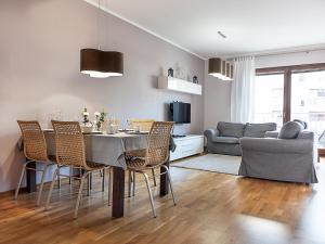 cocina y sala de estar con mesa y sillas en VacationClub - Platan 2E Apartament 12, en Świnoujście