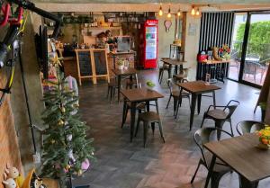 a restaurant with tables and chairs and a christmas tree at JB Place in Nakhon Pathom