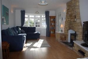 een woonkamer met een bank en een open haard bij Lazy Days Cottage in Winterton-on-Sea