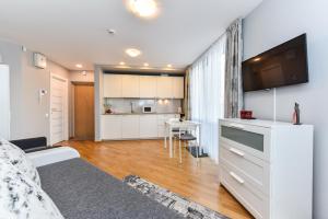 a bedroom with a bed and a kitchen with a table at Apartamentai su terasa Elija in Šventoji