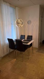 uma mesa de jantar com cadeiras e um lustre em Lomaosake Meritullinraitti 1 B20 em Oulu