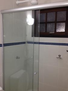 a bathroom with a shower with a glass door at Chalés Ubatuba 102 - P. Itaguá in Ubatuba +9 photos