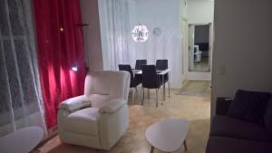 uma sala de estar com uma cadeira branca e uma mesa em Lomaosake Meritullinraitti 1 B20 em Oulu