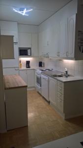 a kitchen with white cabinets and a counter top at Lomaosake Meritullinraitti 1 B20 in Oulu