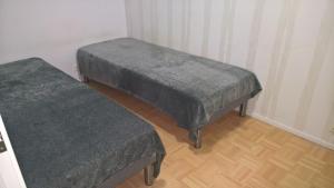 Duas camas cinzentas num quarto com pisos em madeira em Lomaosake Meritullinraitti 1 B20 em Oulu