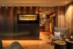 ein Wohnzimmer mit einer Bar und 2 Stühlen in der Unterkunft Hotel Alpina Sölden - Adults Only in Sölden