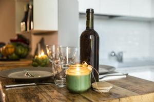 eine Flasche Wein und Gläser auf dem Tisch mit einer Kerze in der Unterkunft borgo 23 holiday in Florence and Tuscany in Lastra a Signa