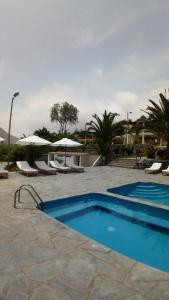 a pool with chairs and umbrellas in a resort at Rio Lindo Ecolodge in Lunahuaná