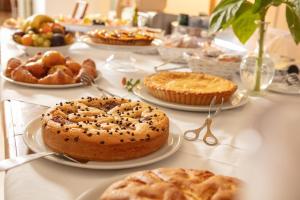 a table with pies and pastries on plates on at Masseria Mongiò dell'Elefante in Otranto