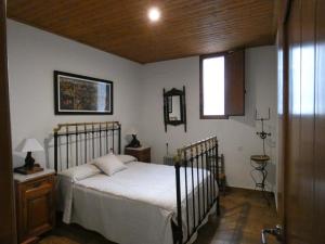 sypialnia z łóżkiem z białą pościelą i oknem w obiekcie Casa Rural Abuela Isabel w mieście Guadalupe