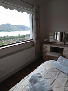a bedroom with a bed and a large window at Viewpoint house in Ardara