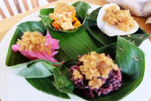 un piatto con quattro diversi tipi di alimenti su una foglia di banana di Rendira Villa ad Ubud