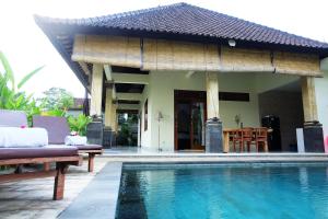 una villa con piscina di fronte a una casa di Rendira Villa ad Ubud