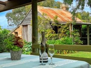Una botella de vino y dos copas en una mesa. en Cherry Plum Cottages, en Port Fairy