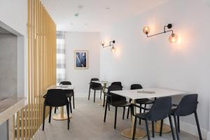 a dining room with tables and black chairs at La Loggia in Labin