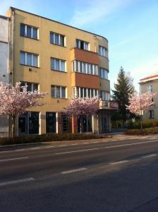 a building with flowering trees in front of a street at Apartmán Turnov - Český ráj in Turnov