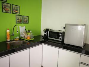 a kitchen with a counter with a microwave and a refrigerator at De Centrum Duplex Apartment near Bangi, Kajang in Kajang