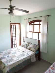 a bedroom with a bed and a ceiling fan at Bertioga-Costa do Sol MK9 in Praia Guaratuba +31 photos