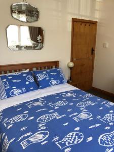 a bedroom with a bed with blue and white bedsheets at Art Deco Apartment #10 sea views, centre of town. in Picton