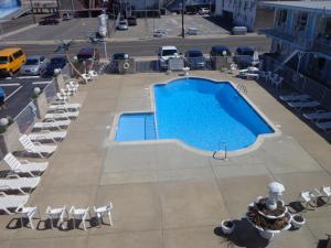 an overhead view of a large swimming pool with lounge chairs at Caprice Motel - Wildwood in Wildwood
