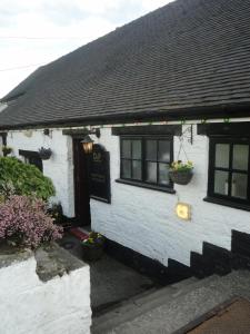 a white house with two windows and a door at The Dog & Partridge Country Inn in Ashbourne