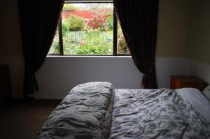 een slaapkamer met een bed voor een raam bij David's House in Oamaru