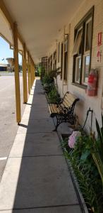 a row of benches on a sidewalk next to a building at Lakes Entrance Holiday Units in Lakes Entrance