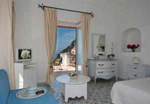 a room with a bed and a table and a window at Villa Rosa in Positano