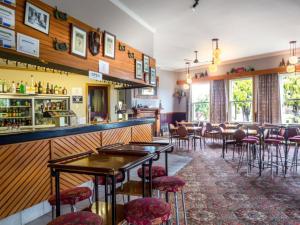 a bar with chairs and tables in a restaurant at Karamea Village Hotel in Karamea