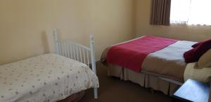 a small bedroom with two beds and a window at Lakes Entrance Holiday Units in Lakes Entrance
