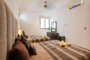 a bedroom with two beds and a couch at Central Luxury Apartment Playa del Carmen in Playa del Carmen