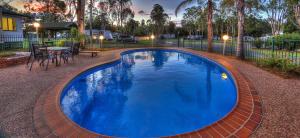 棕櫚灘花園的住宿－BIG4 Warwick Holiday Park，一个带桌椅的大型蓝色游泳池