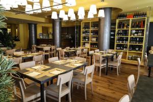 a restaurant with tables and chairs and wine bottles at Apartment Hotel Marchesini in Ravenna