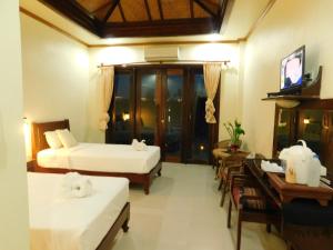 Ban Khon的住宿－Sengahloune Villa，客房设有两张床、一张桌子和一台电视。