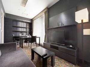 a living room with a couch and a tv at Sotetsu Grand Fresa Tokyo-Bay Ariake in Tokyo