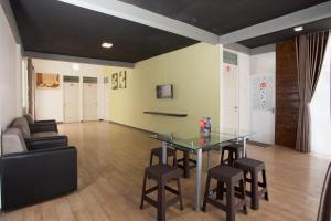 Zimmer mit einem Tisch, Stühlen und einem Sofa in der Unterkunft RedDoorz near Museum Angkut Batu 2 in Malang