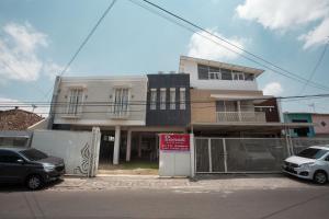 a building with cars parked in front of it at RedDoorz near Museum Angkut Batu 2 in Malang