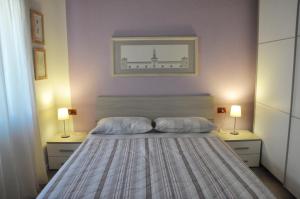 a bedroom with a bed with two lamps on both sides at Casa della Magnolia in Conegliano