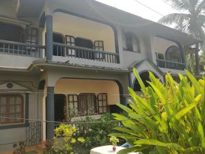 ein Haus mit Balkonen und Pflanzen davor in der Unterkunft Koito-House calangute guest house in Calangute